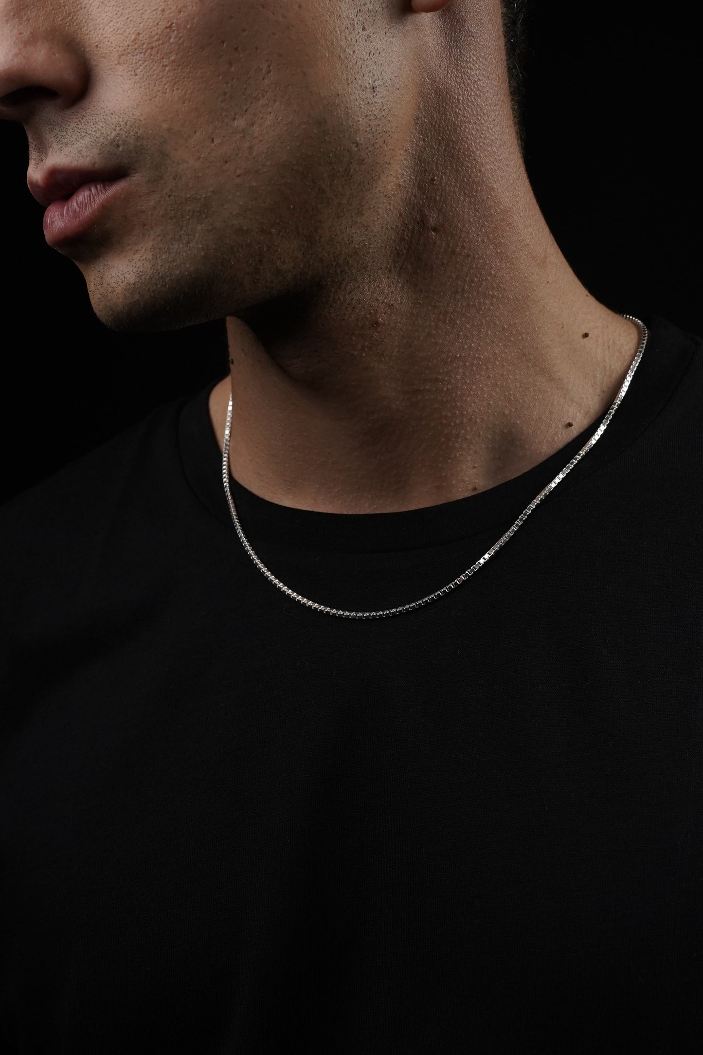 Close-up of a person's neck with a dark background