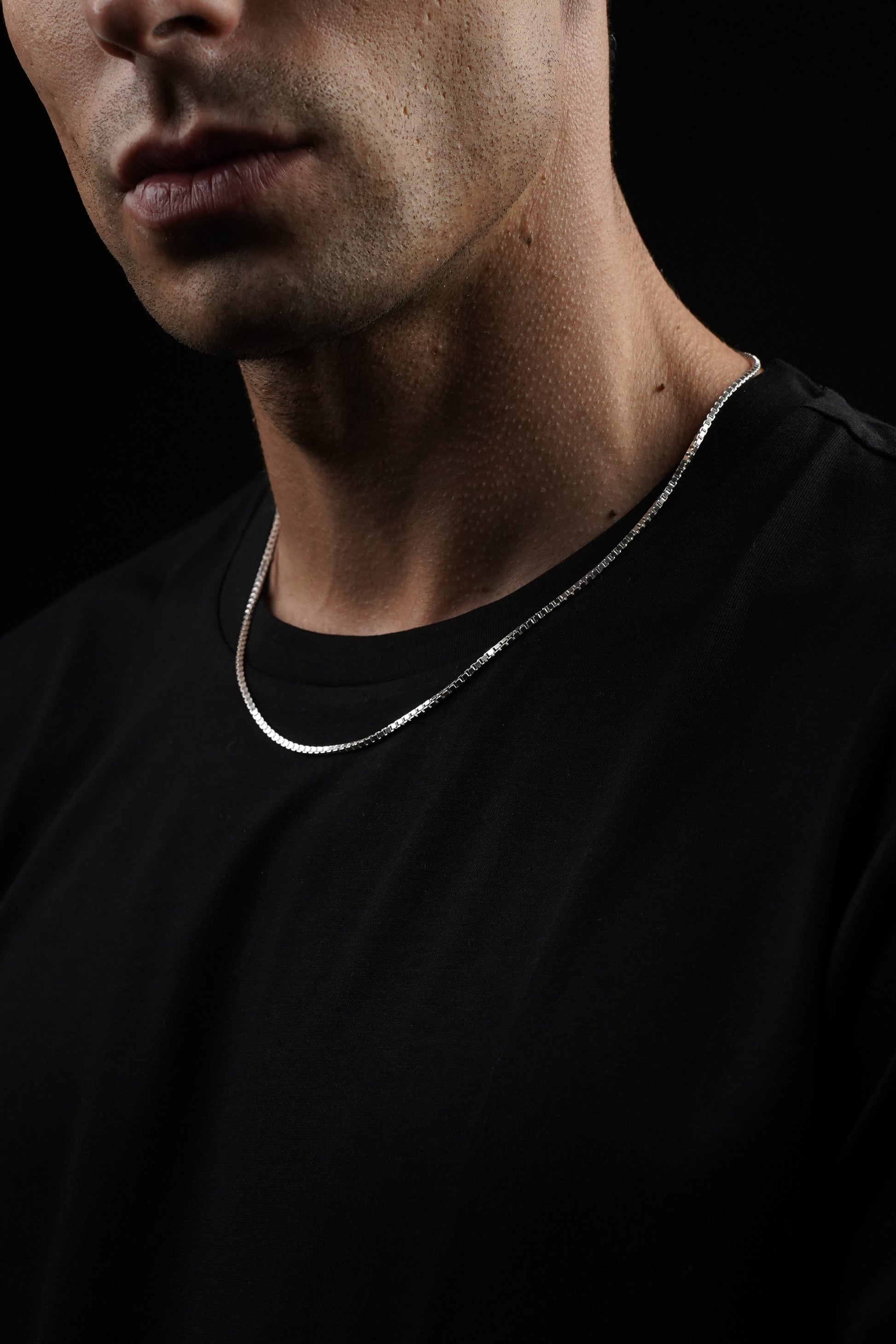 Close-up of a person's neck and shoulders with a dark background
