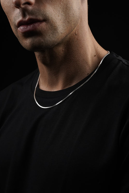 Close-up of a person's neck and shoulders with a dark background