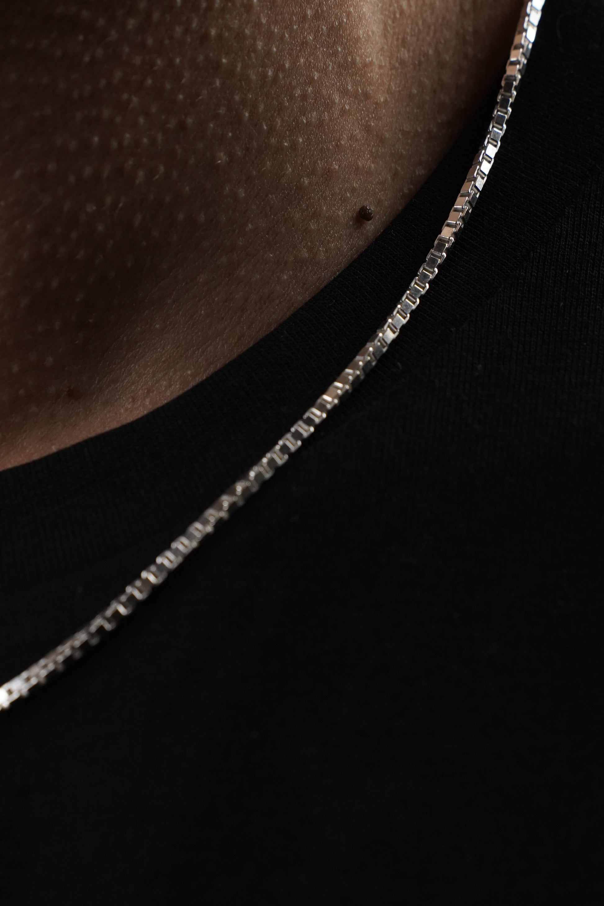 Close-up of a silver chain on a dark background