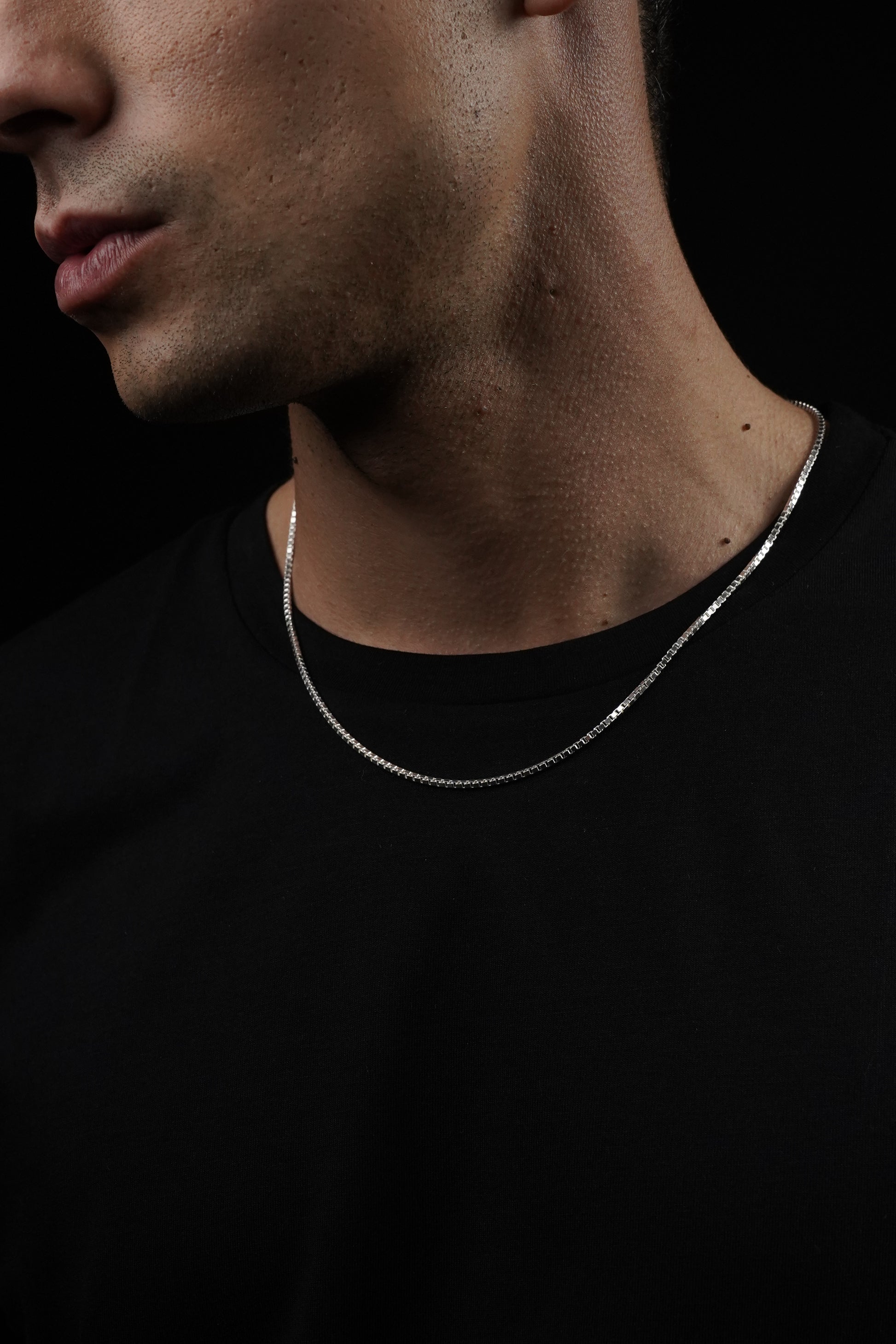 Close-up of a person's neck with a dark background
