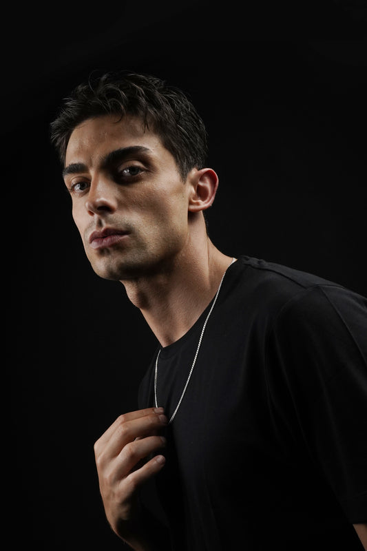 Man wearing a black shirt against a black background