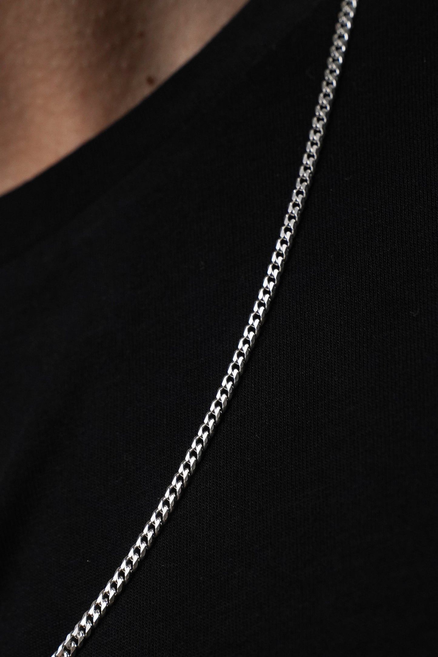 Silver chain necklace on a black background