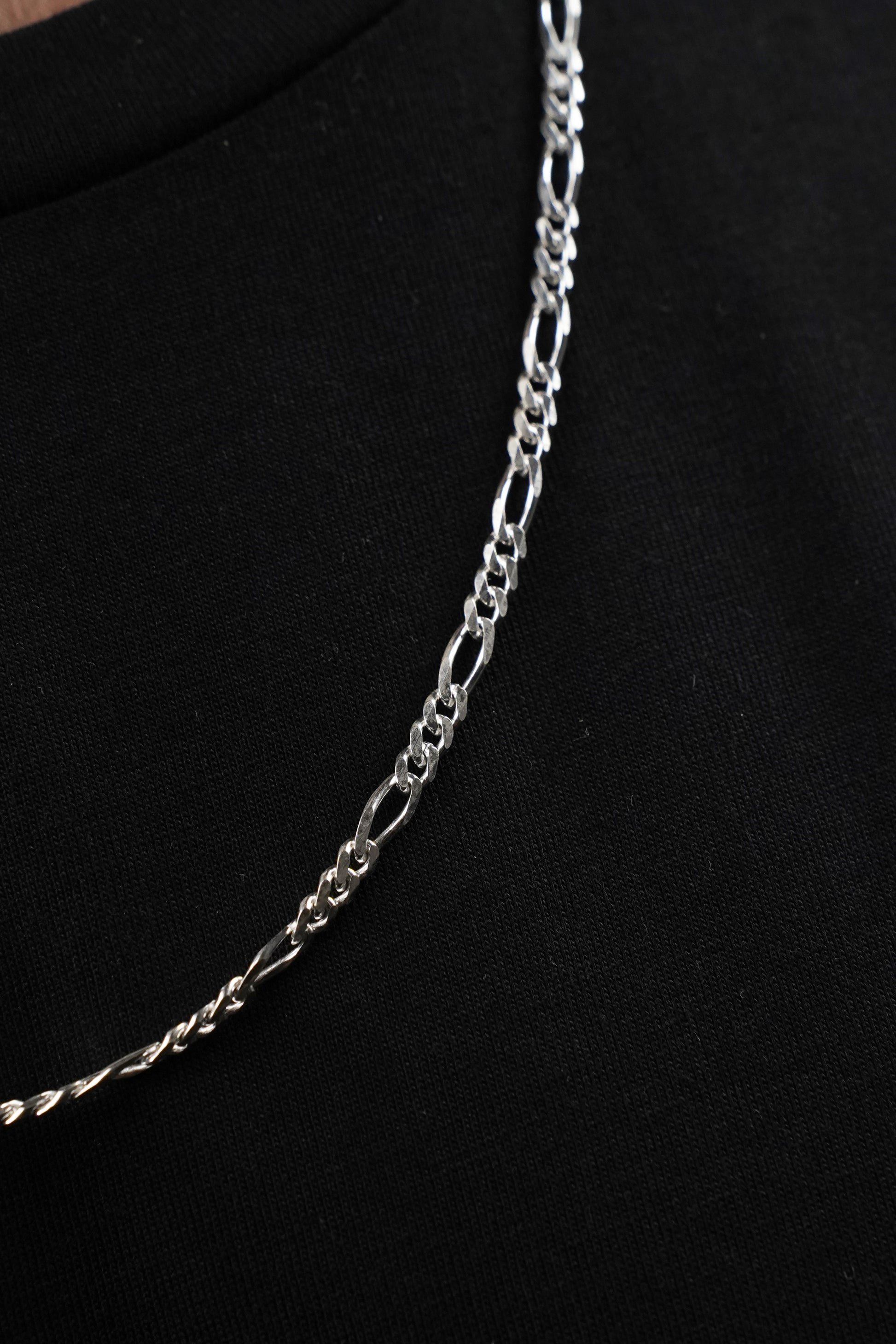 Silver chain necklace on a black background