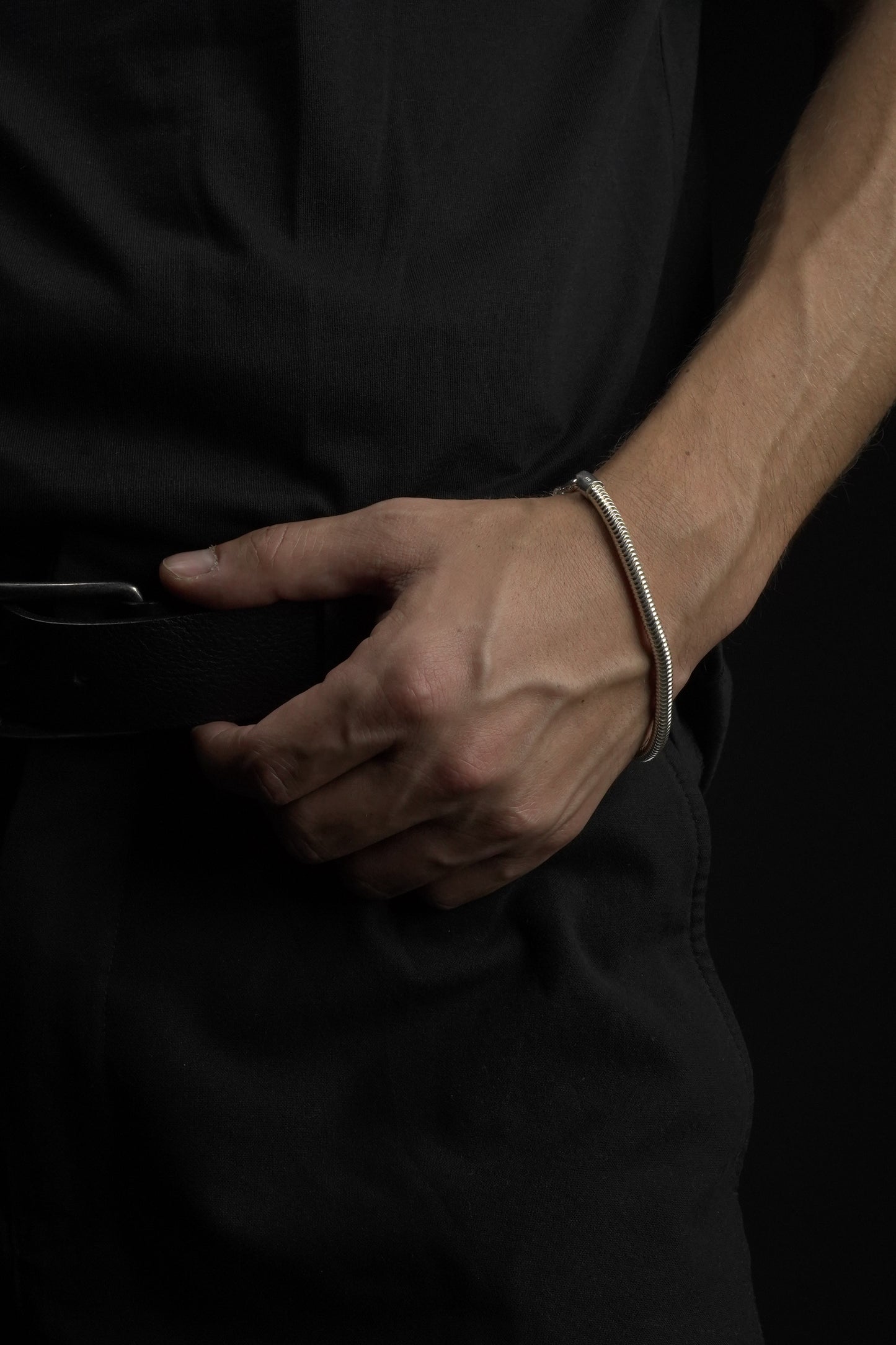 Handcuffed hand of a person against a dark background