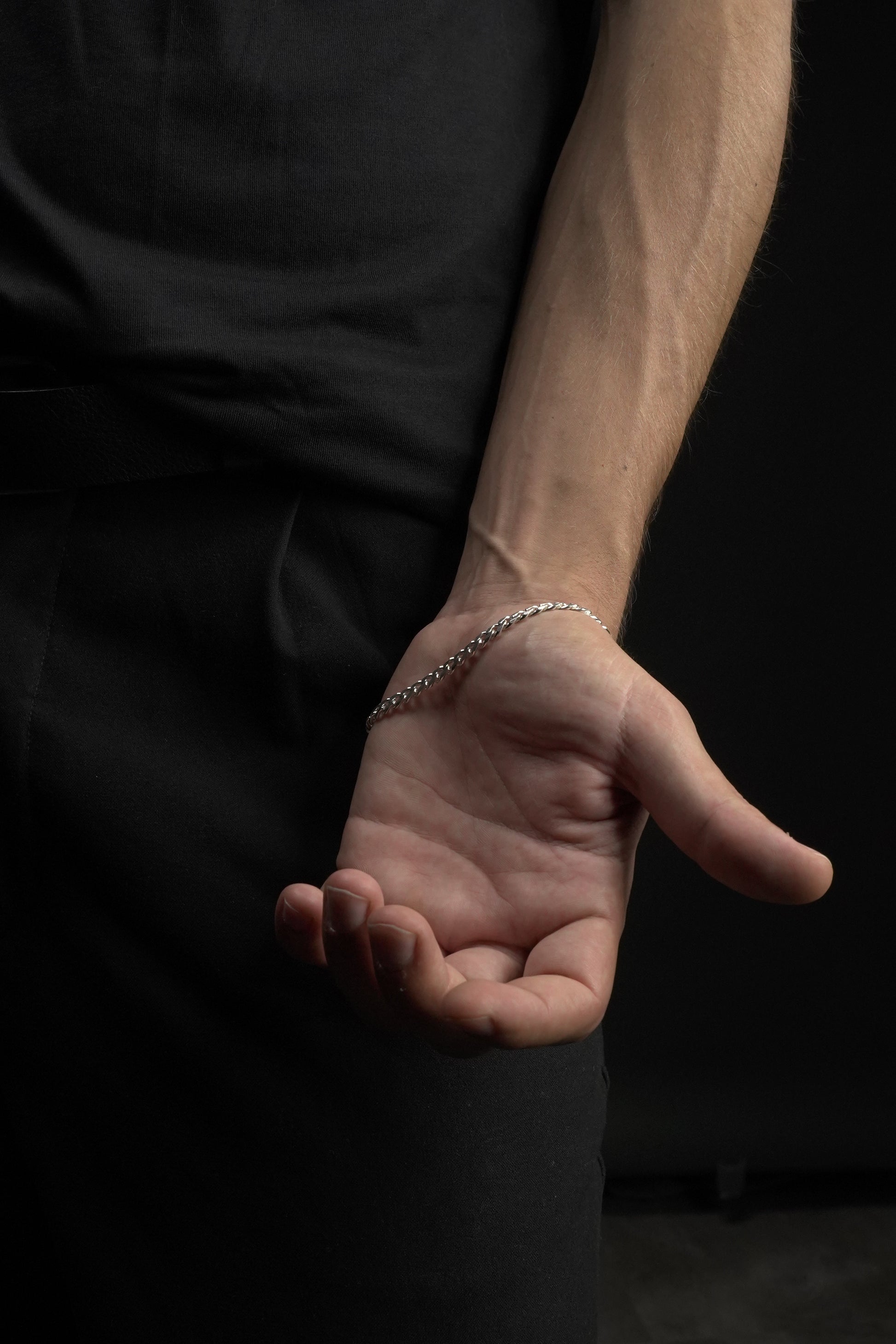 Hand making a thumbs-down gesture against a dark background
