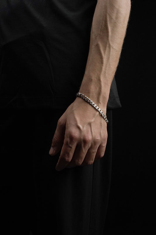 Hand wearing a bracelet on a black background