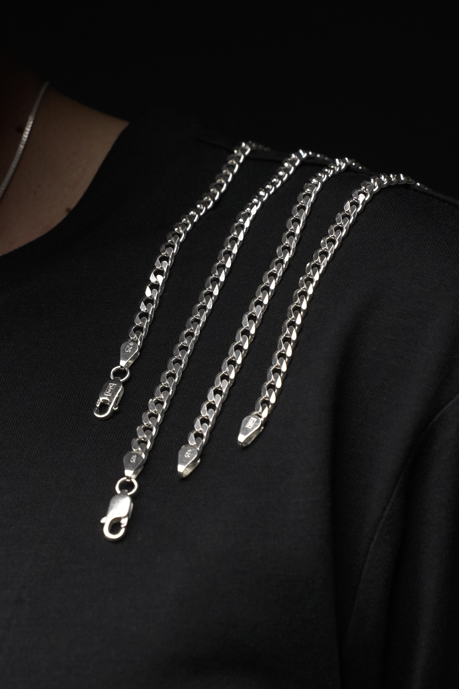 Silver chain necklace on a black background