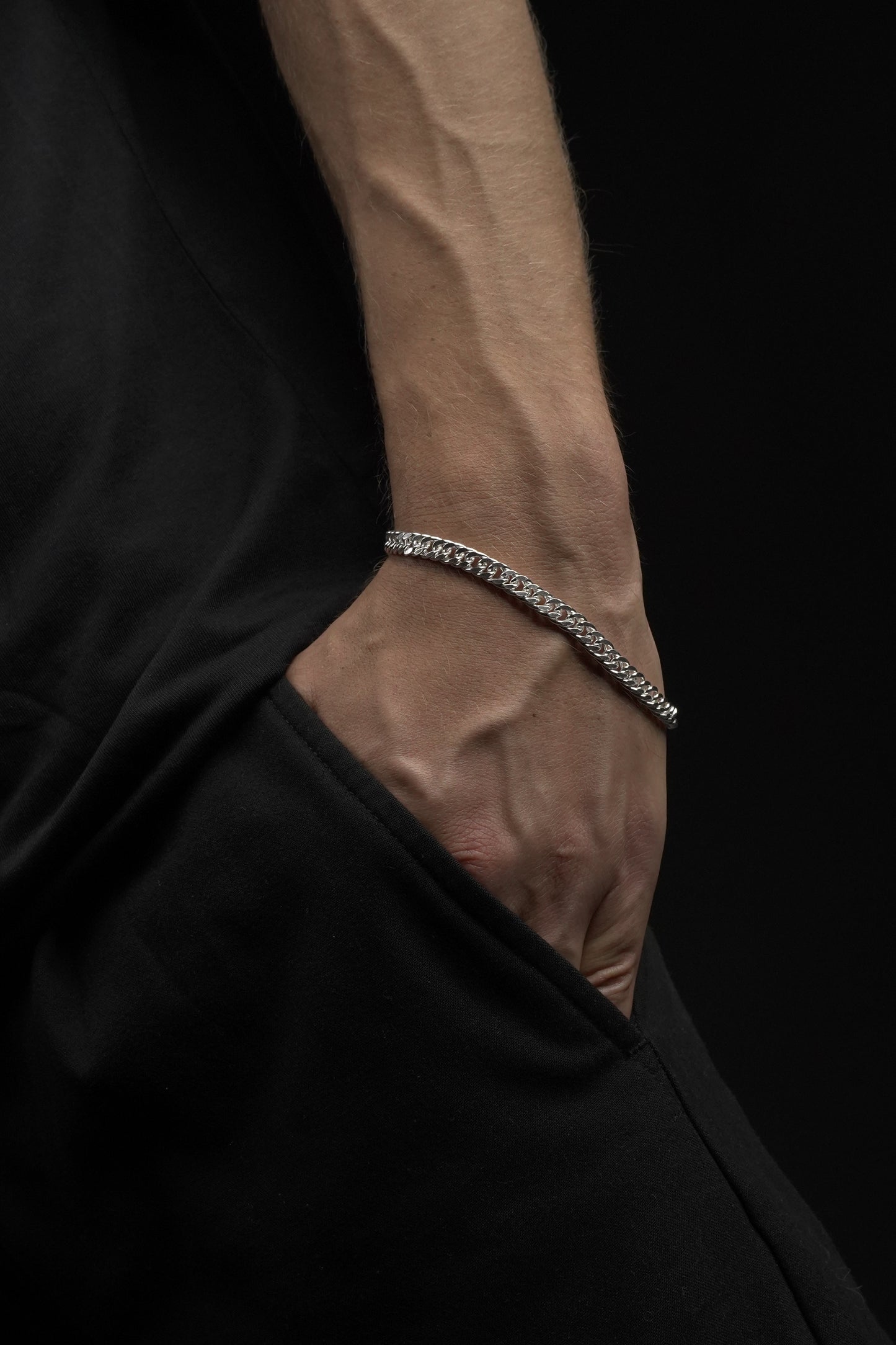 Close-up of a black garment with a brown lining and a silver chain detail.